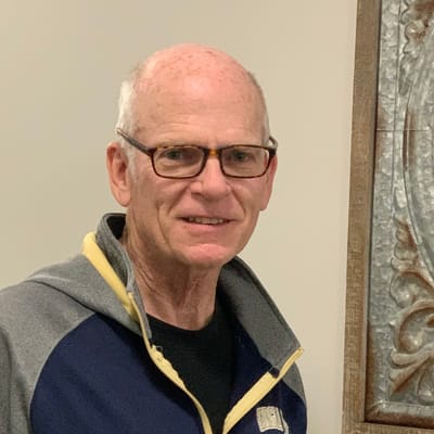 A resident with glasses smiling indoors