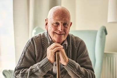 Smiling elderly man sitting in an armchair
