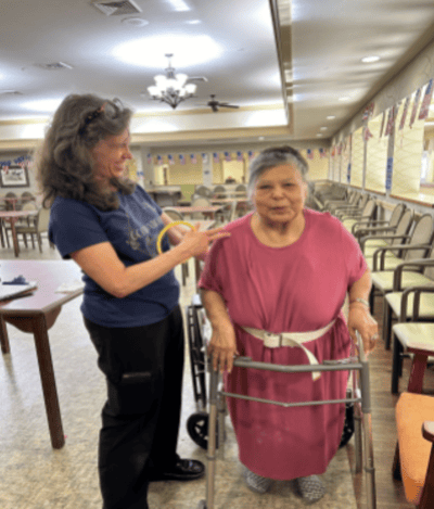 Staff assisting a resident in a common area.
