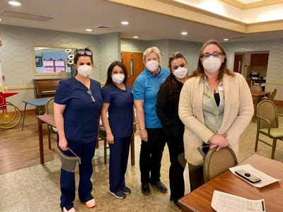 Healthcare staff posing together in common area.