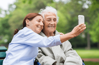 Resident and staff member sharing a selfie outdoors.