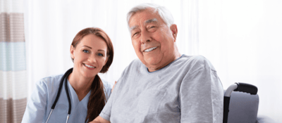 Nurse and resident smiling together in a care environment.