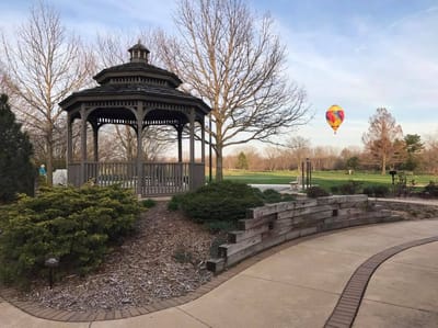 A gazebo in a garden with a hot air balloon