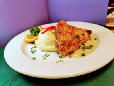 Plated fish dish with sides and garnish
