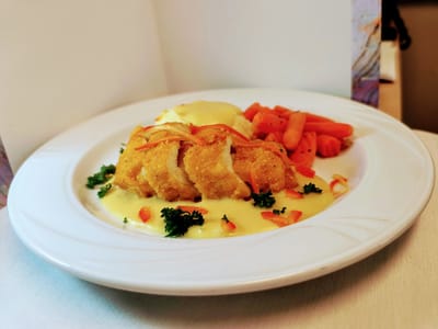 A plated meal with fish, vegetables, and sauce.