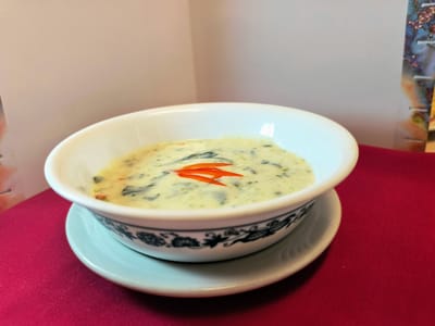 Bowl of creamy soup garnished with peppers.