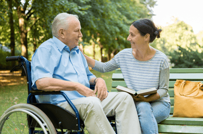 A resident and caregiver enjoying a moment outdoors.