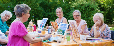 Residents engaged in an outdoor painting activity.