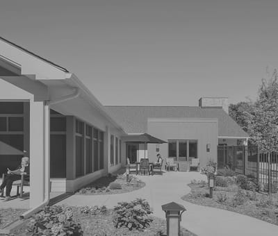 Outdoor area with residents relaxing and pathways.