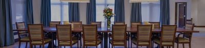 Modern dining room setup with flower centerpiece.