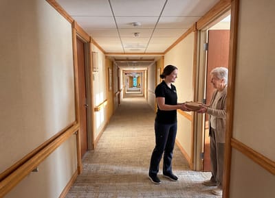 Staff member delivering a package to a resident.