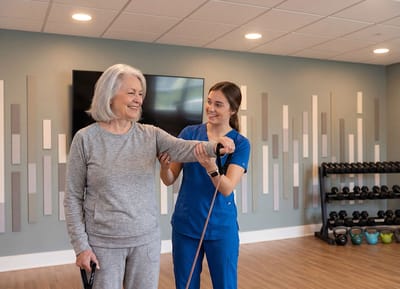Senior resident exercising with staff assistance