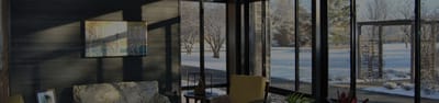 Sunlit common area with seating and views of snow outside.