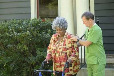 Care staff assisting a resident outdoors