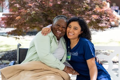 Happy resident and staff member sharing a joyful moment outdoors