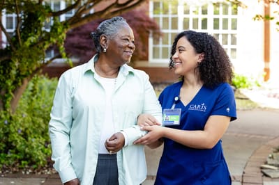 A caregiver assisting a resident outdoors