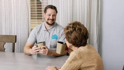 Staff member engaging with a resident over coffee