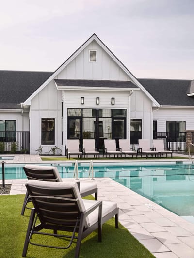 Outdoor pool area with lounge chairs and building facade