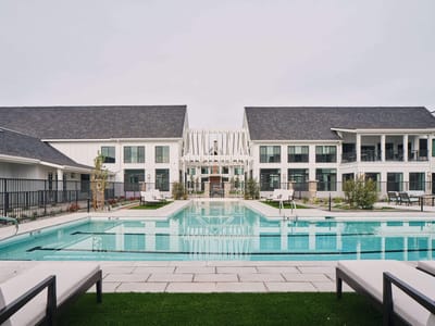 Exterior view of a modern senior living facility with a pool