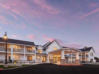 Modern senior living facility exterior at dusk