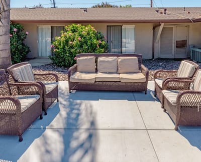 Outdoor seating area with wicker furniture and greenery