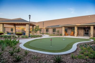 Outdoor putting green surrounded by landscaping