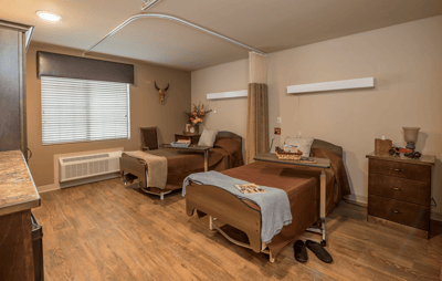 Private resident room with two beds and bedside tables