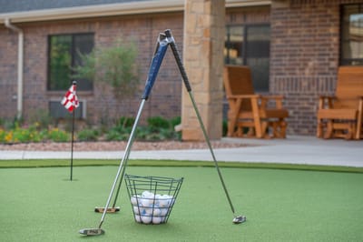 Mini golf setup with clubs and balls in an outdoor area