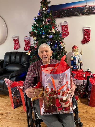 Resident celebrating with holiday gifts.
