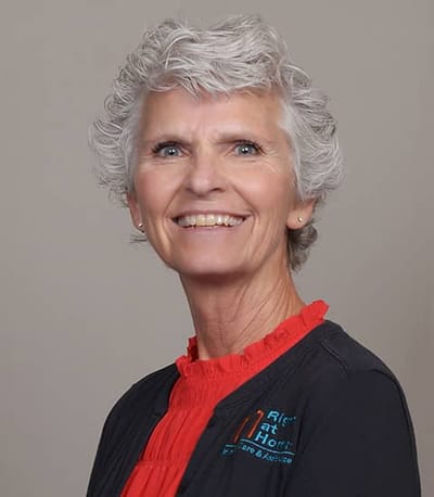Smiling staff member with company logo attire.