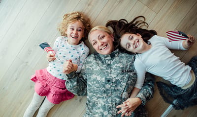 A soldier with two children holding flags.