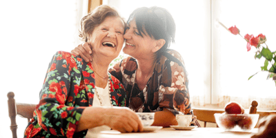 Two women laughing together at a table