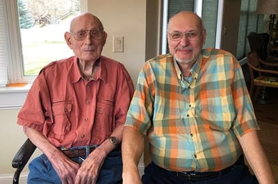 Two smiling male residents in a cozy setting.