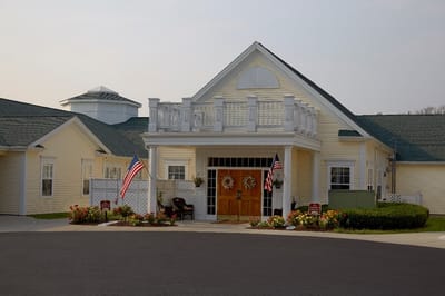 Exterior view of the facility with flags and flowers.