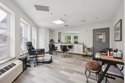 Interior view of a beauty salon area with chairs and mirrors.