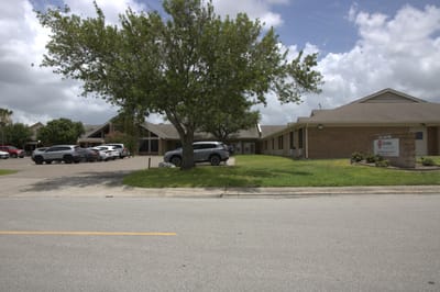 Exterior view of Caraday facility with parked cars and landscaping