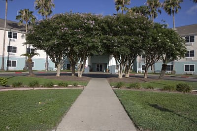 Path leading to the entrance of Cimarron Estates with trees