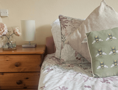 Cozy bedroom with floral bedding and decorative pillows.