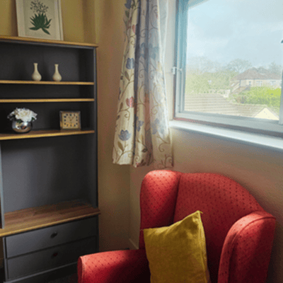 Cozy corner in a resident room with a chair and decor.