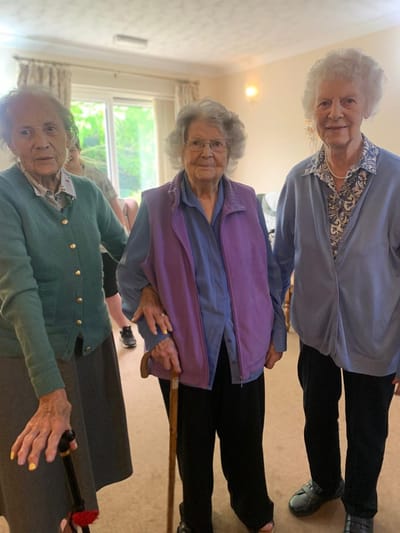 Three elderly residents in a common area.