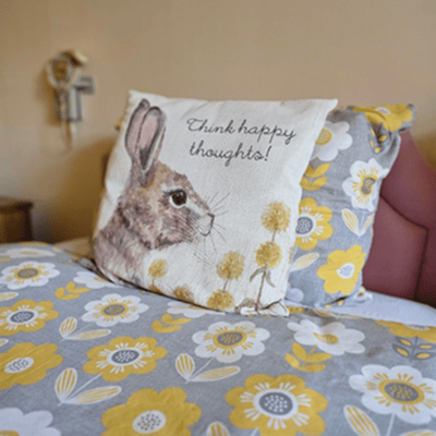 Cozy bed with decorative pillow featuring a rabbit