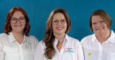 Three staff members smiling together.