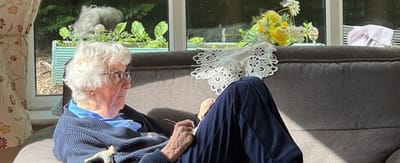 An elderly resident relaxing on a couch.