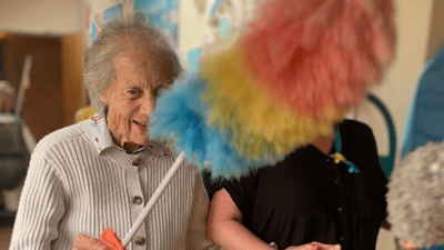 Resident engaging in a fun cleaning activity.