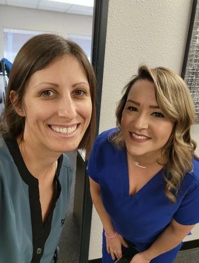 Two staff members smiling together in an office