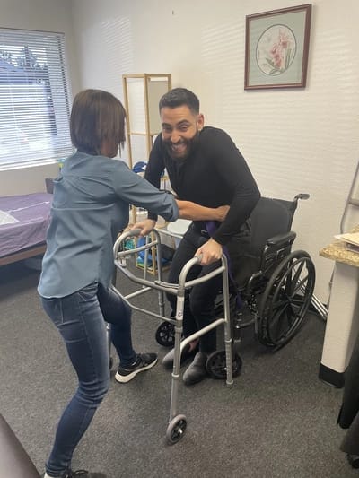 Staff assisting a resident with mobility equipment.