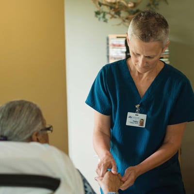 Staff member assisting resident in a care setting.