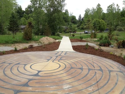 Outdoor labyrinth pathway surrounded by greenery.