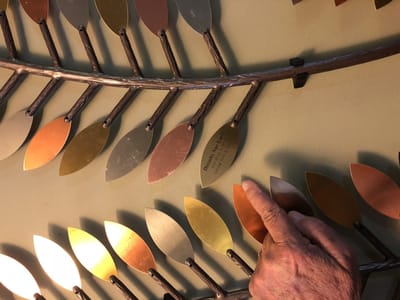 A hand pointing at a memory wall with leaves.