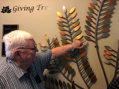 Resident interacting with a decorative wall tree.